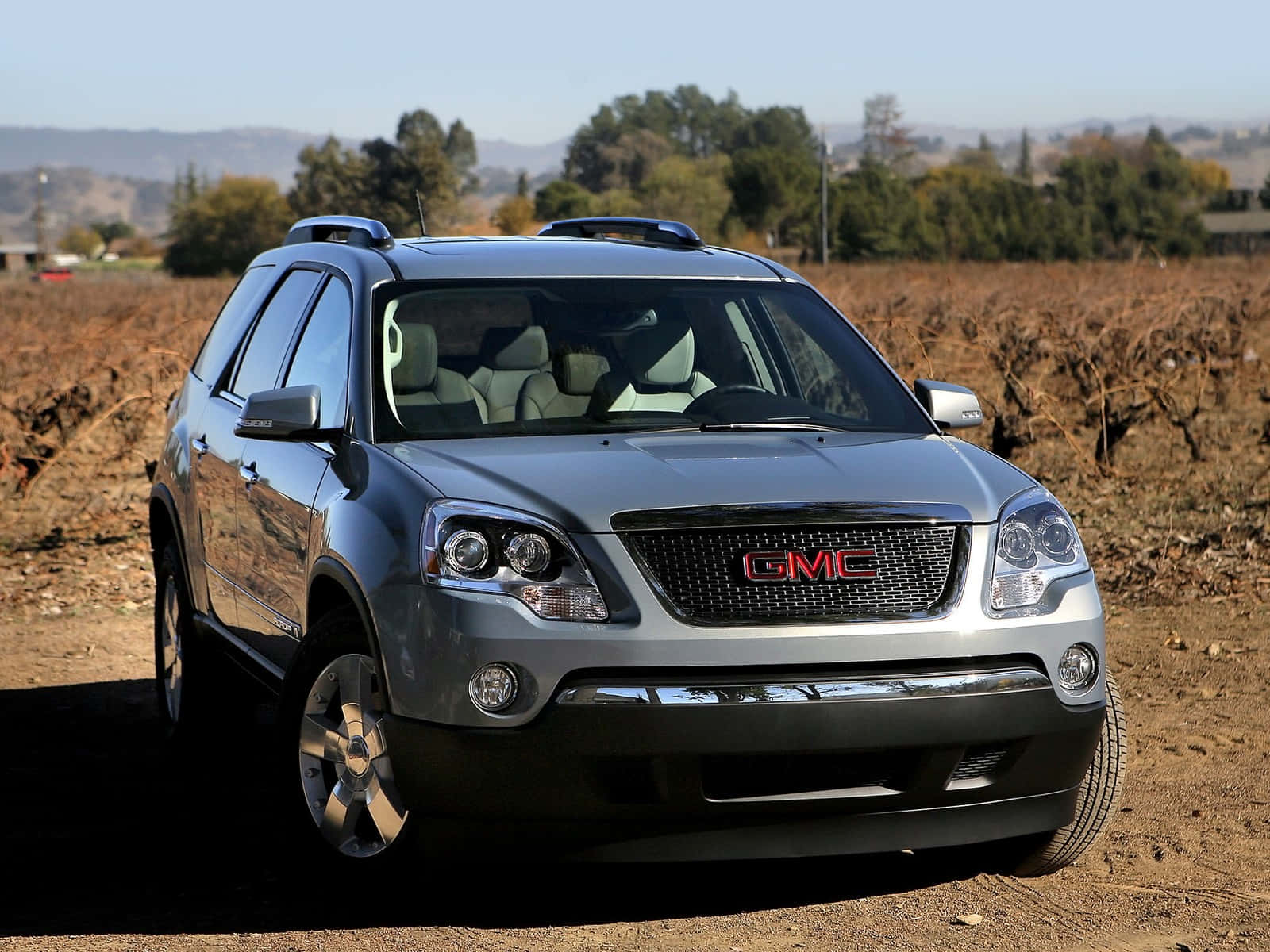 GMC Acadia on a scenic mountain road Wallpaper