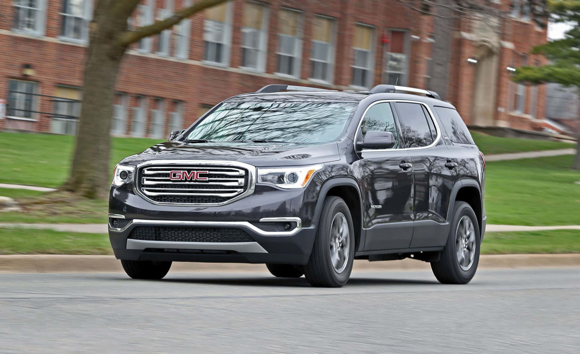 Sleek and versatile GMC Acadia cruising through the open road Wallpaper