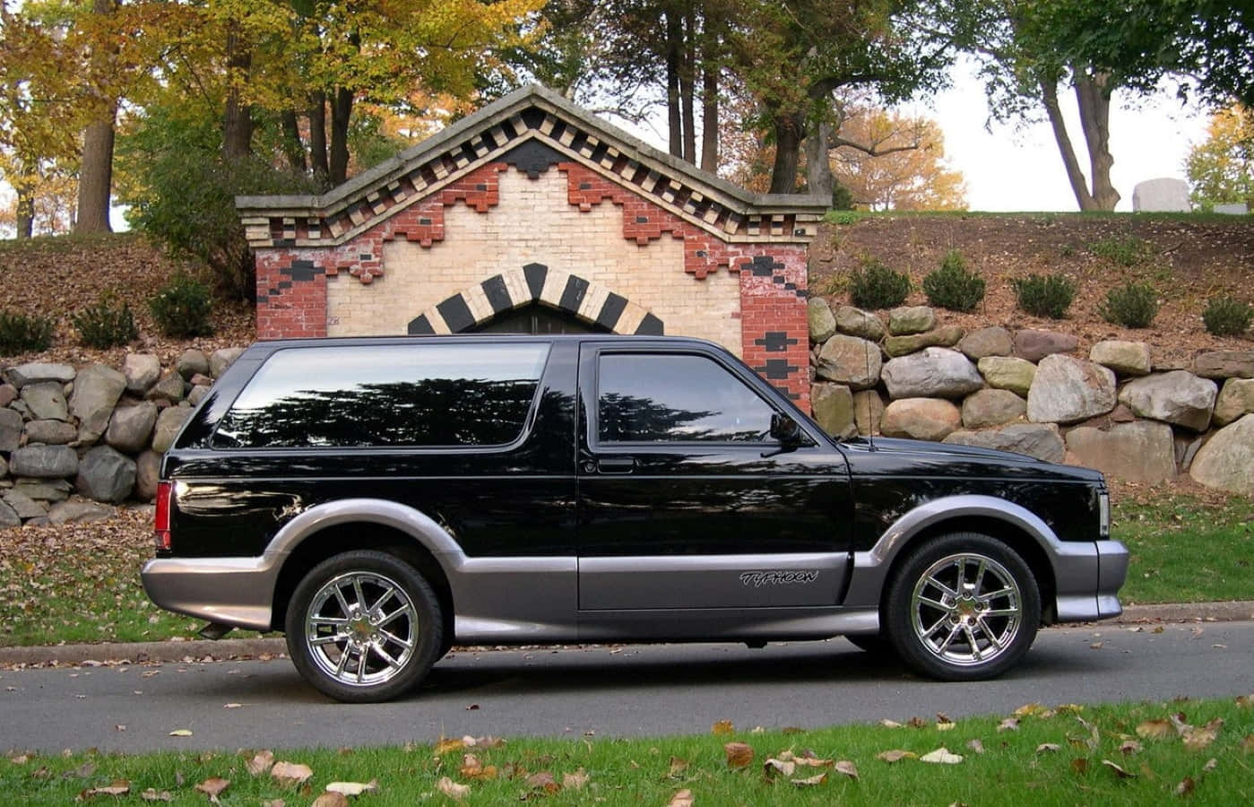 A sleek and powerful GMC Typhoon showcased on a scenic road Wallpaper