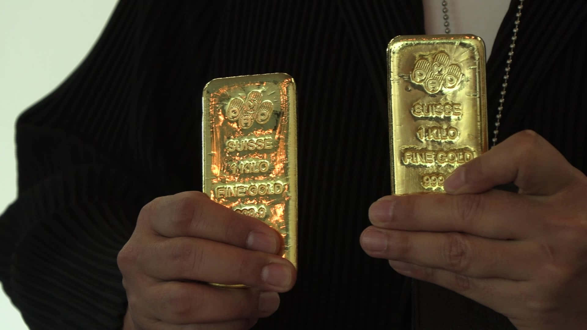 Two Men Holding Gold Bars In Their Hands