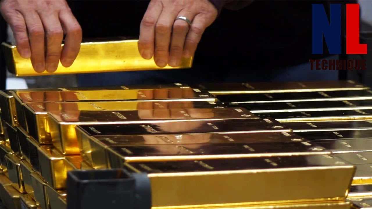 A Man Is Putting Gold Bars Into A Stack