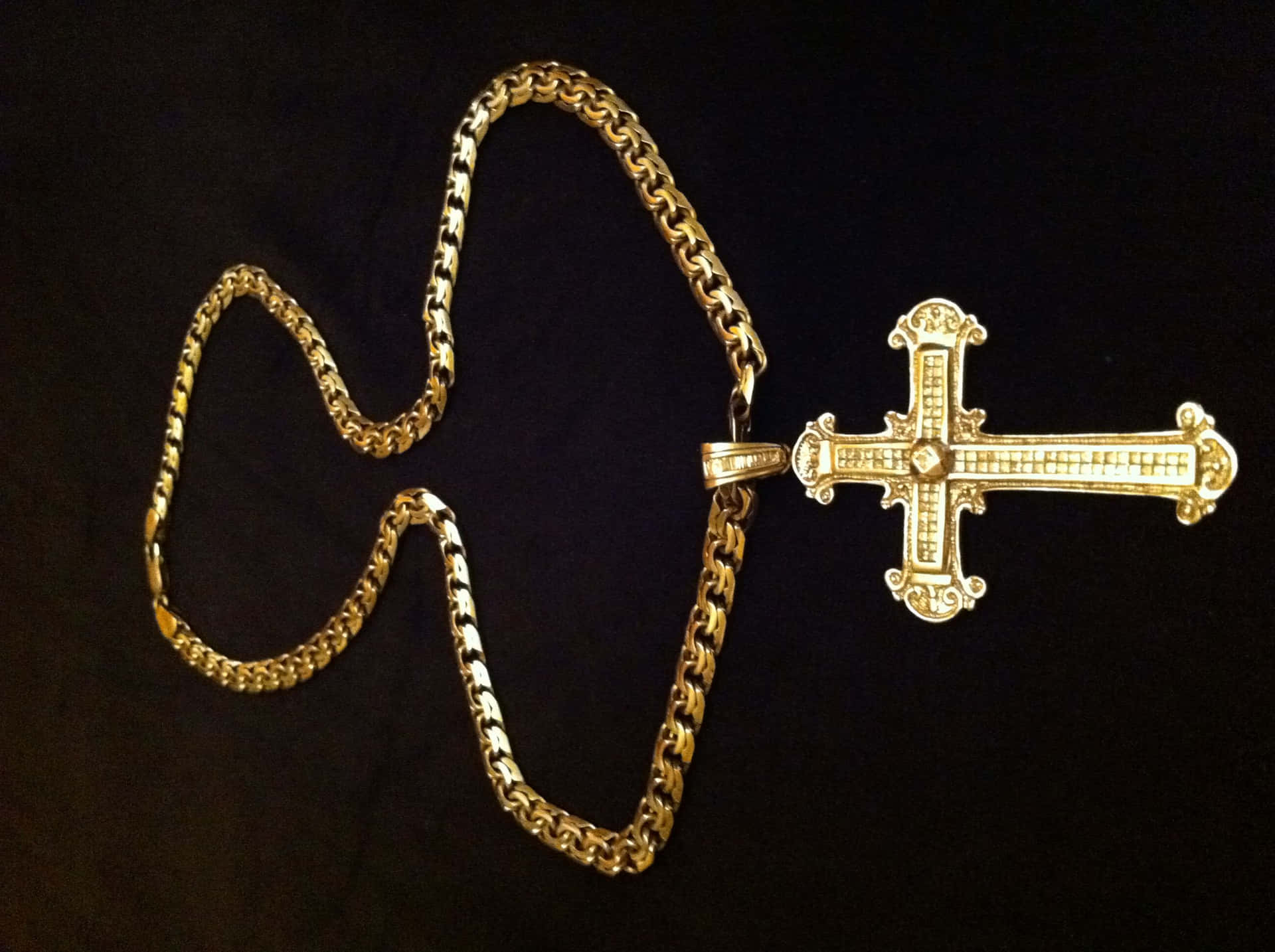 A Gold Chain With A Cross On It Wallpaper