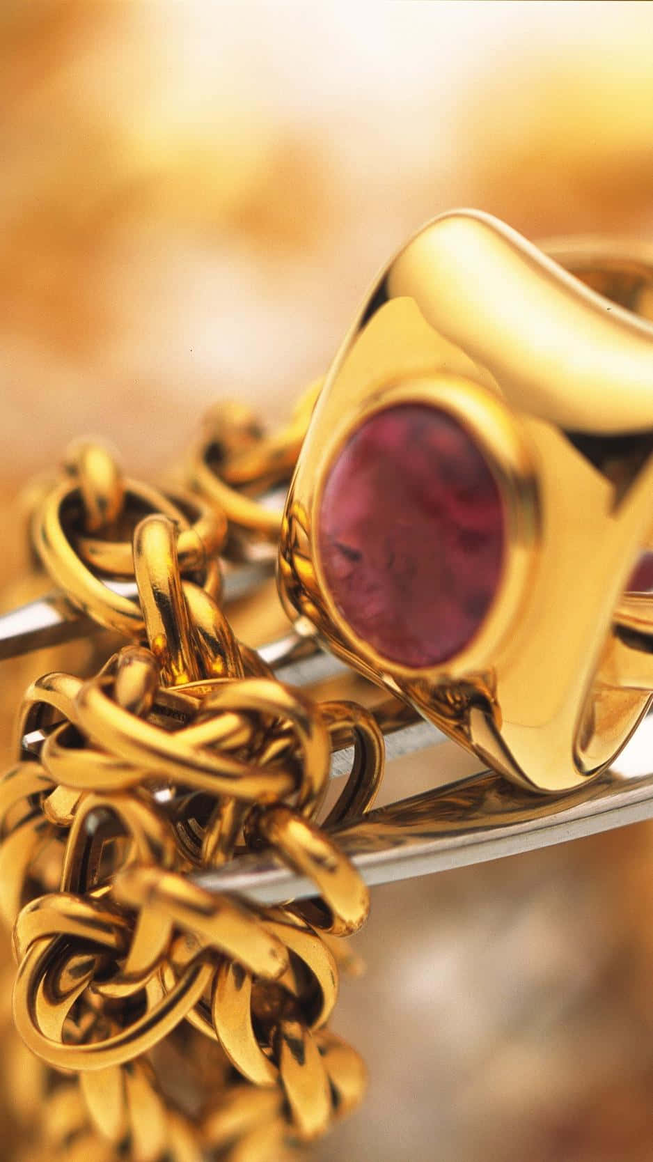 A Gold Ring With A Pink Stone Wallpaper