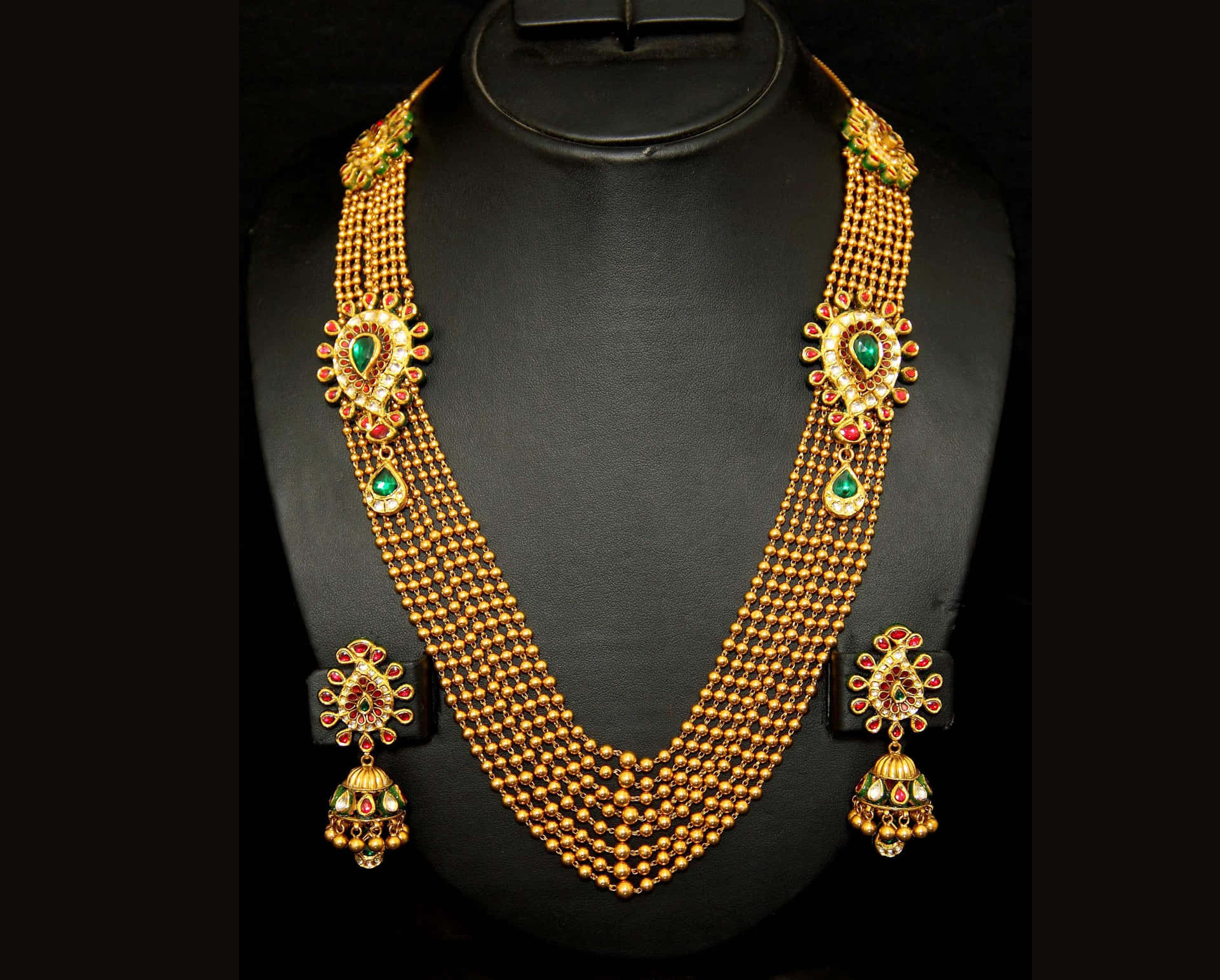 A Gold Necklace Set With Emeralds And Emeralds Wallpaper