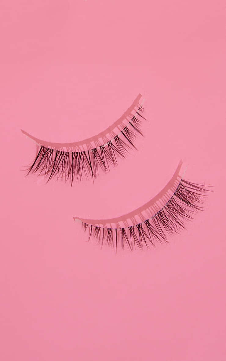 Two False Eyelashes On A Pink Background Wallpaper