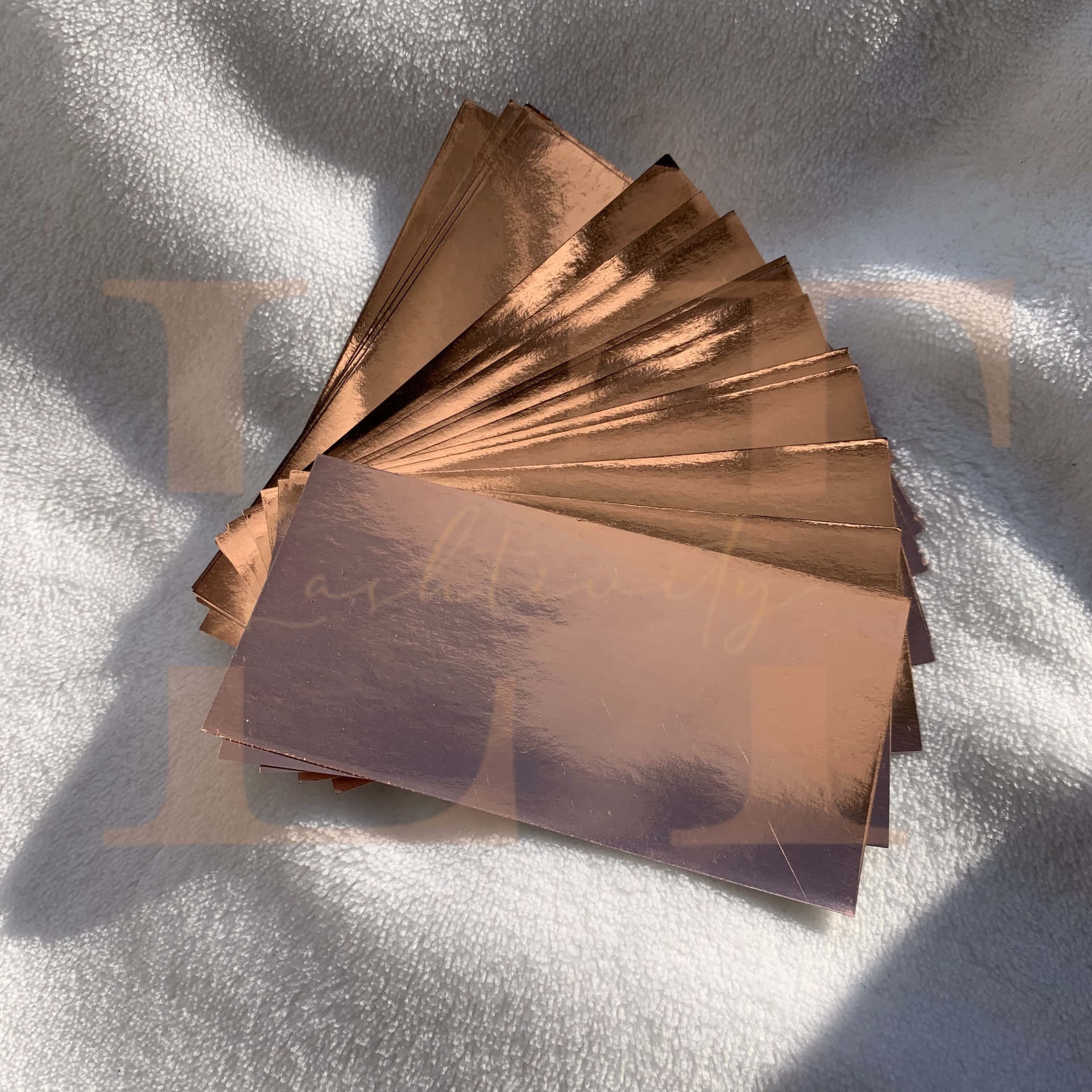 A Set Of Copper Foil Cards On A White Blanket Wallpaper