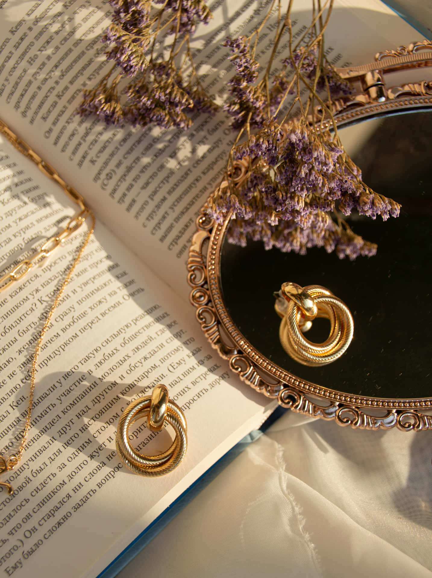 A Gold Ring And A Book On A Table