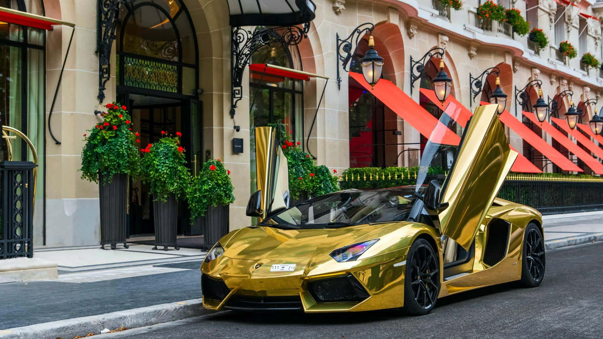 En guld sportsvogn parkeret foran et hotel. Wallpaper