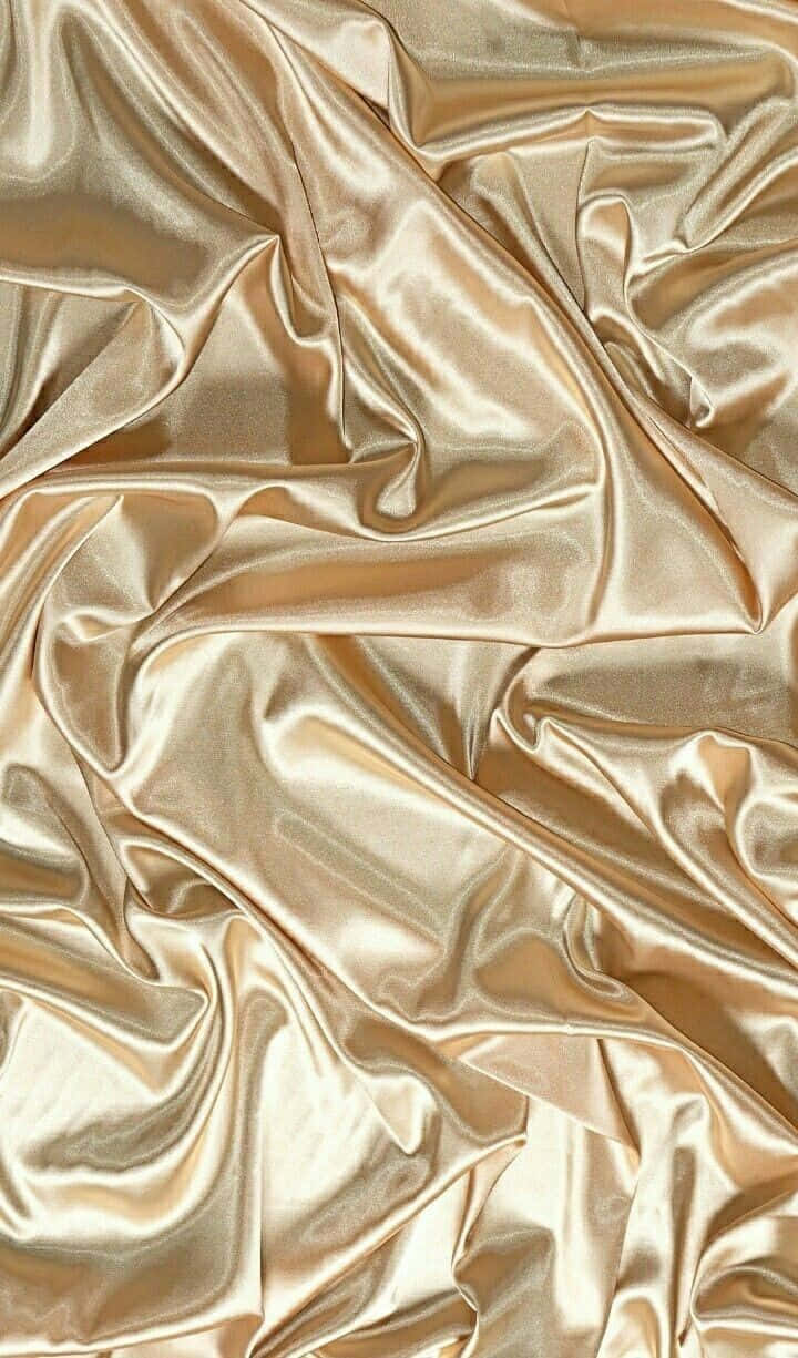 Rich golden silk fabric shining in the light. Wallpaper