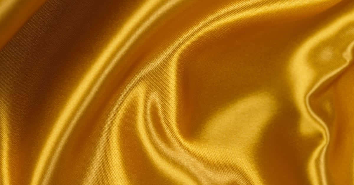En tæt op af en gul satin stof Wallpaper