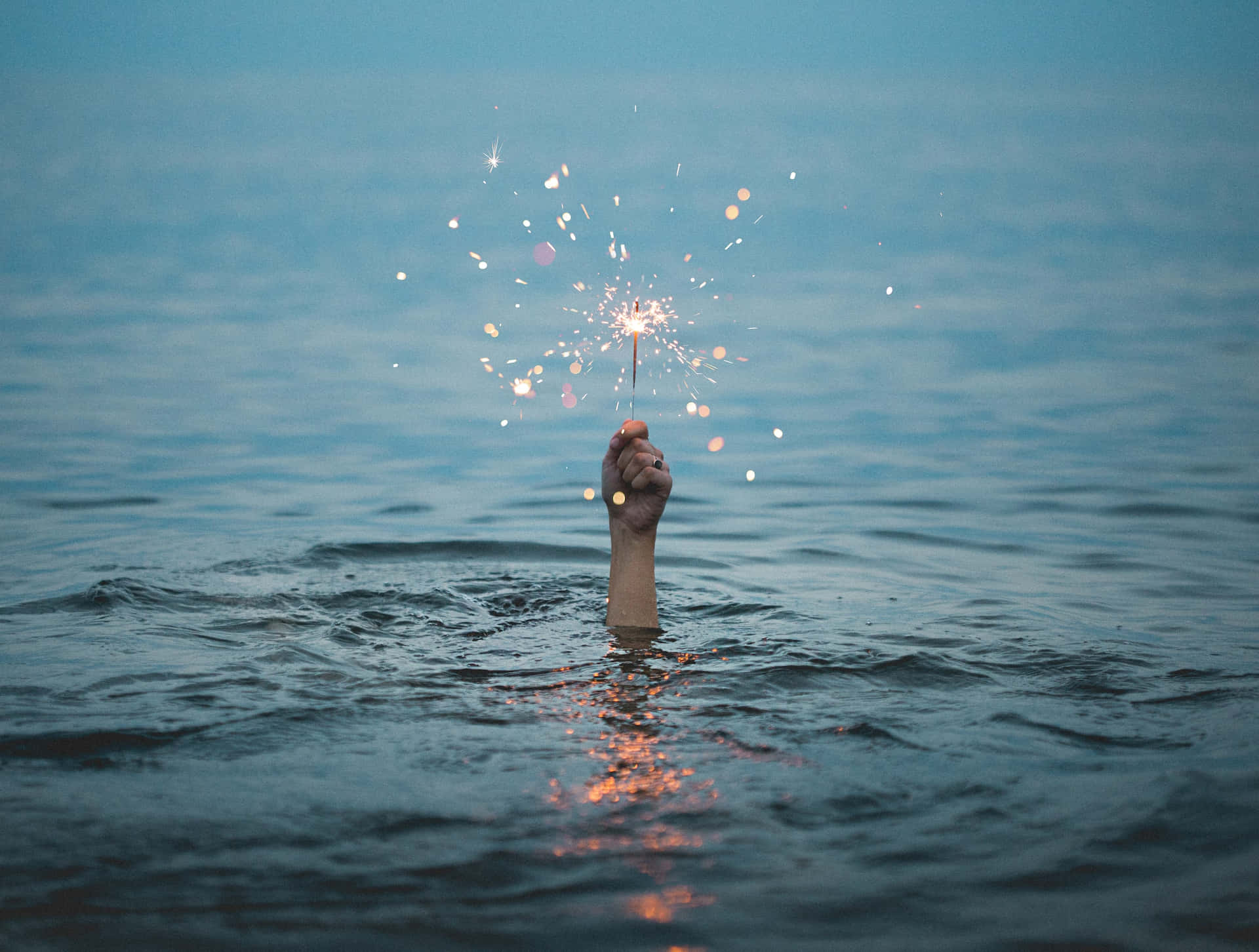 Gold Sparkle Held By Hand Underwater Background