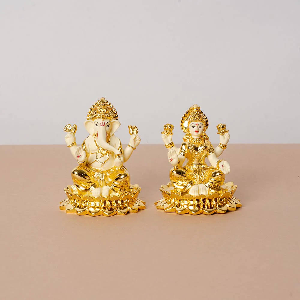 Divine Golden Statuettes Of Ganesh And Lakshmi Wallpaper