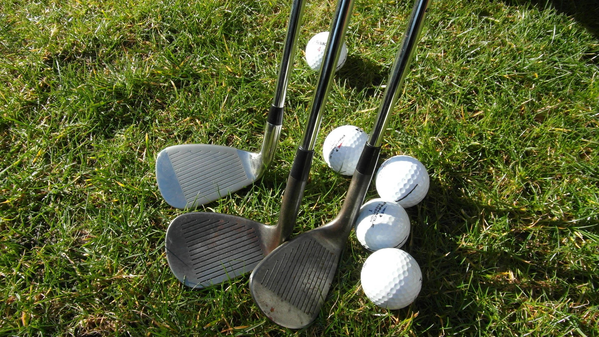 Golf Club Heads And Balls On Golf Course Wallpaper