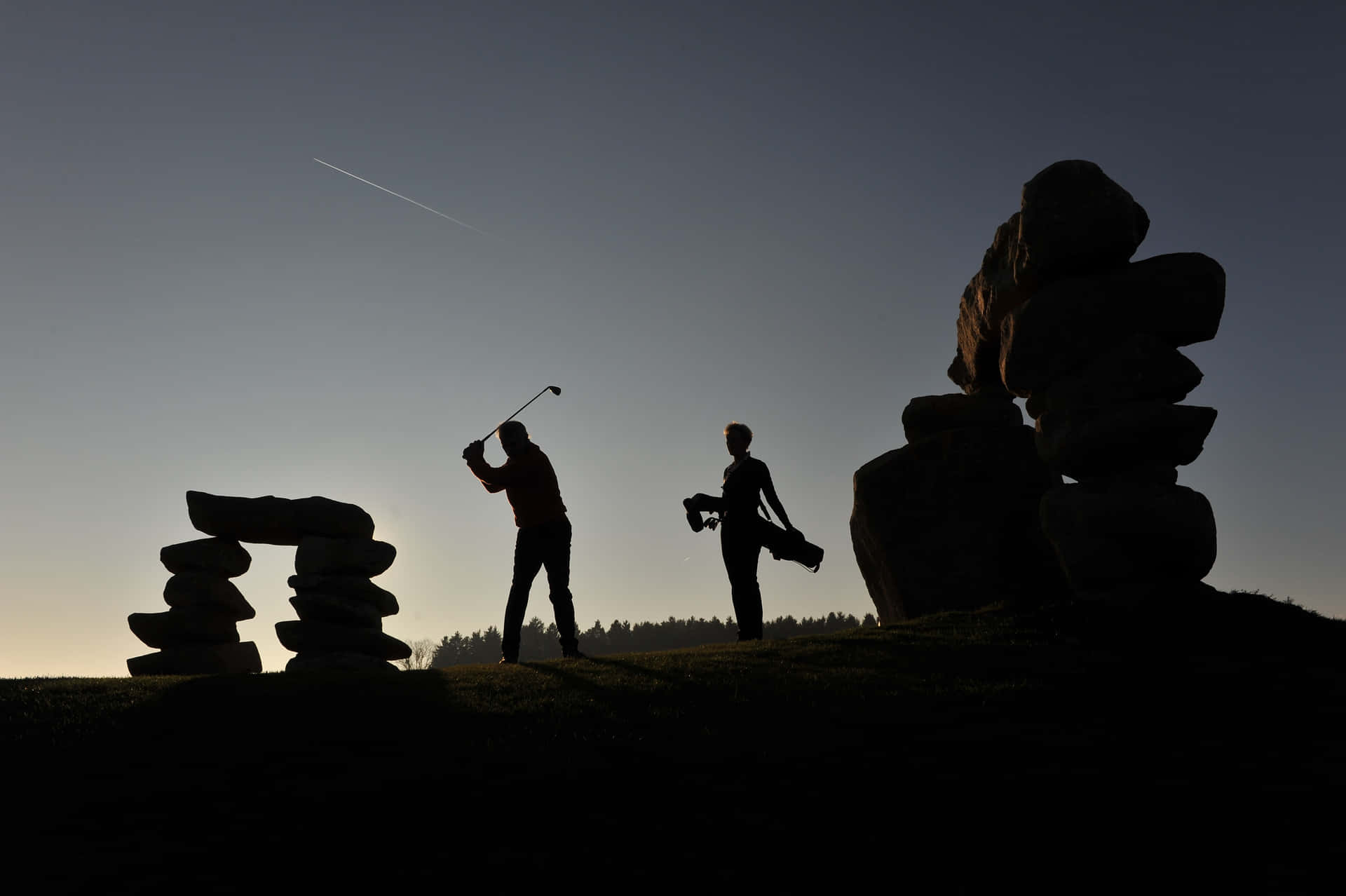 Silhouette Of Two People Playing Golf