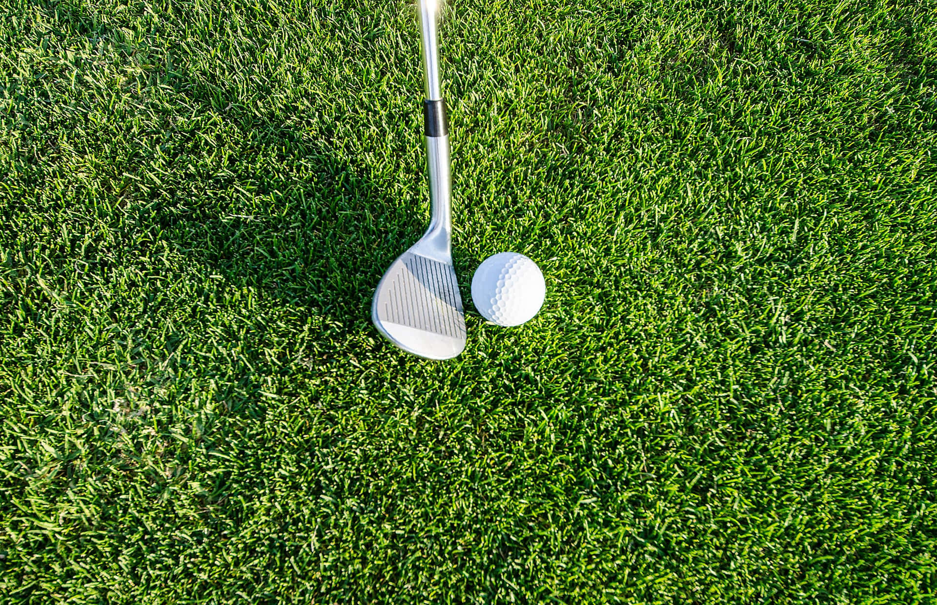 A Golf Club And Ball On The Grass