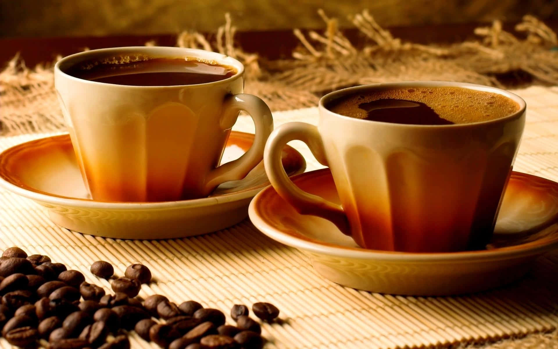 To kopper kaffe på et bord med kaffebønner