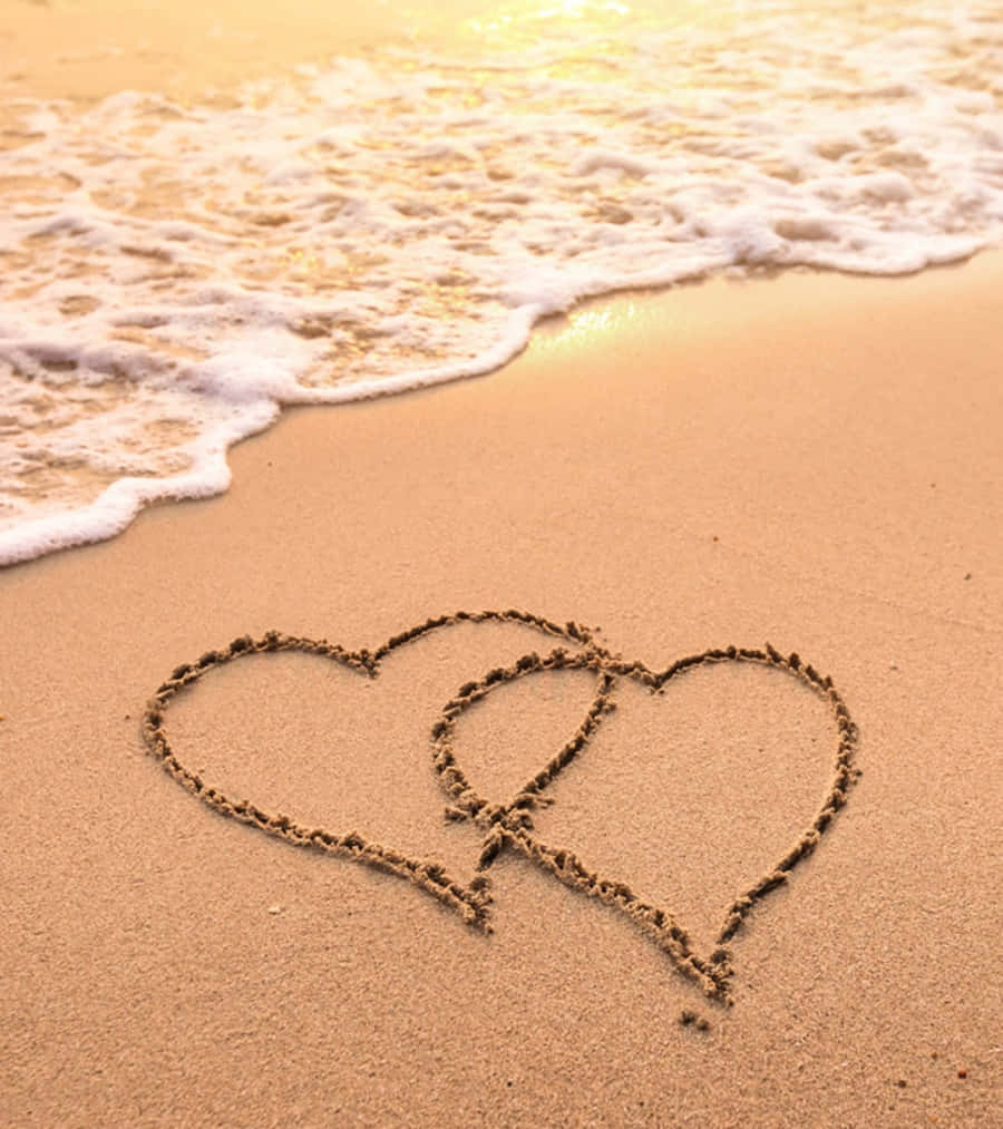 To hjerter tegnet i sandet på stranden