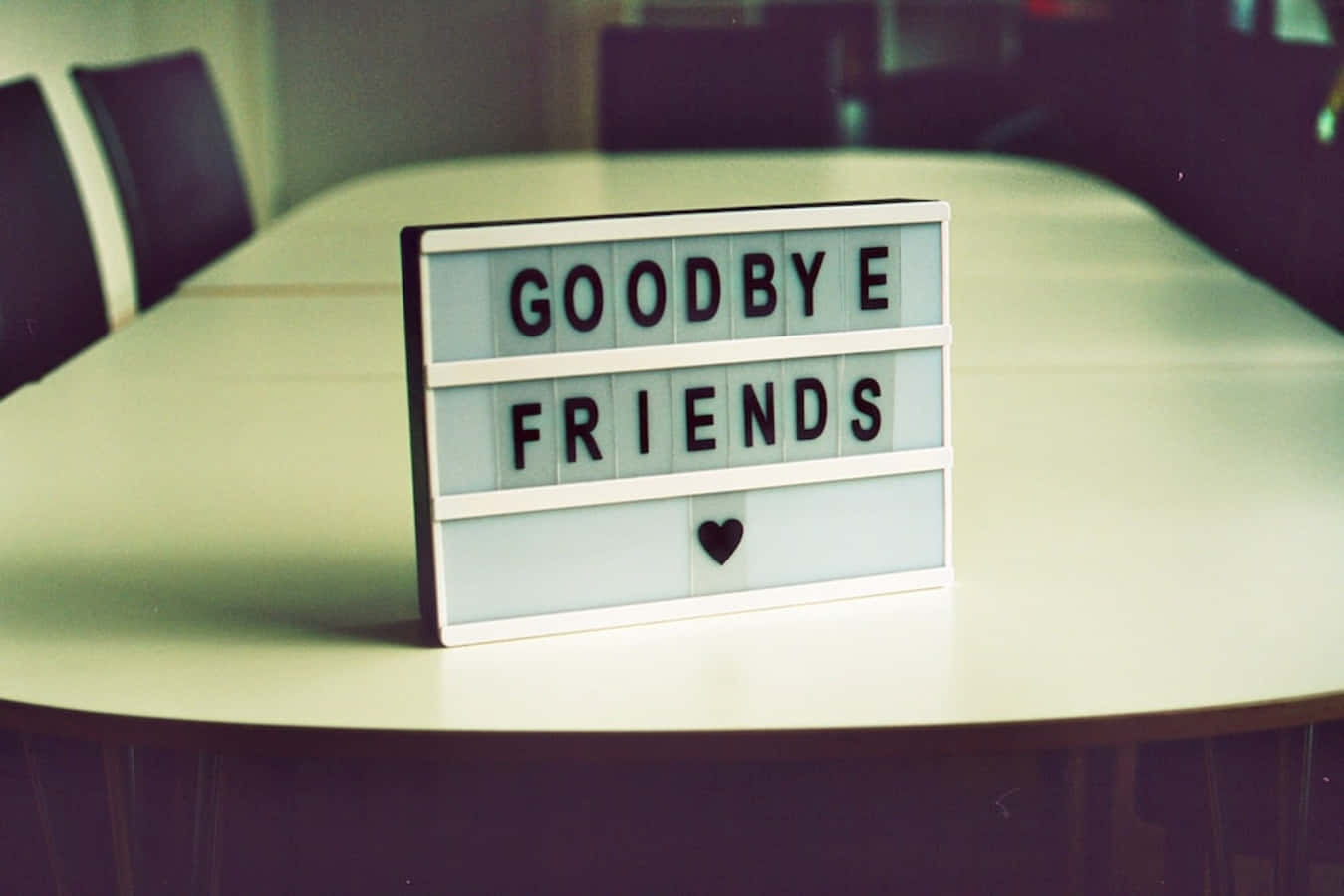 A White Table With A Sign That Says Goodbye Friends