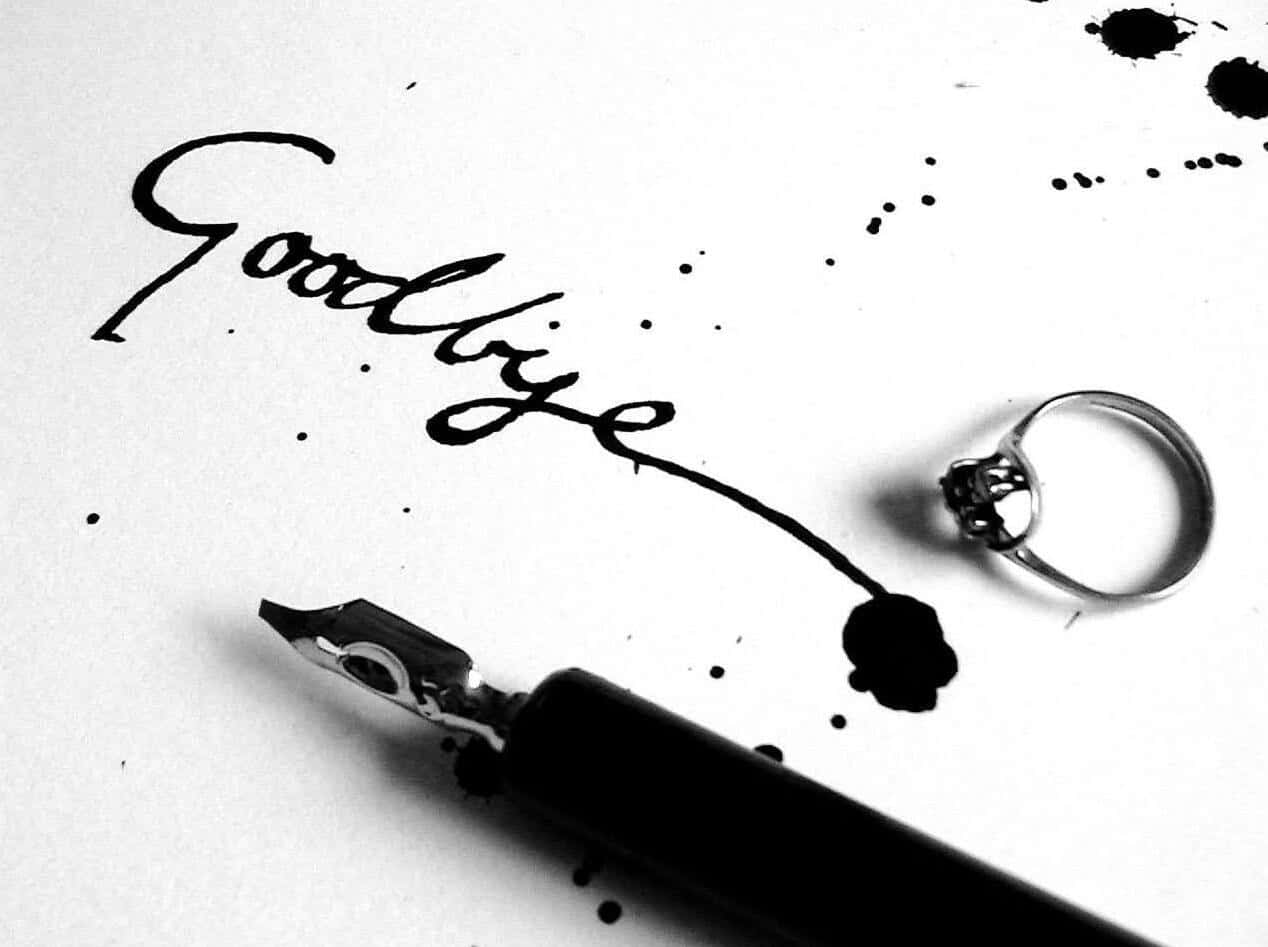 A Black And White Photo Of A Ring And A Pen With The Word Goodbye