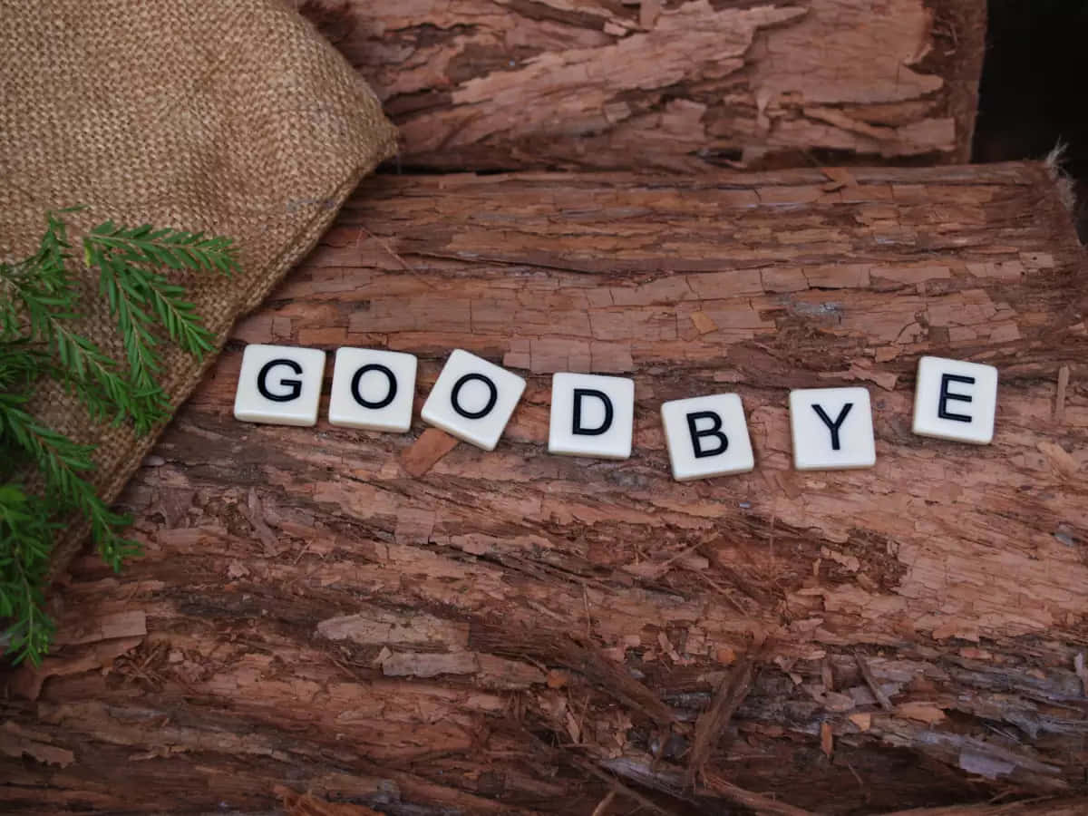 A Wooden Board With The Word Goodbye Spelled Out