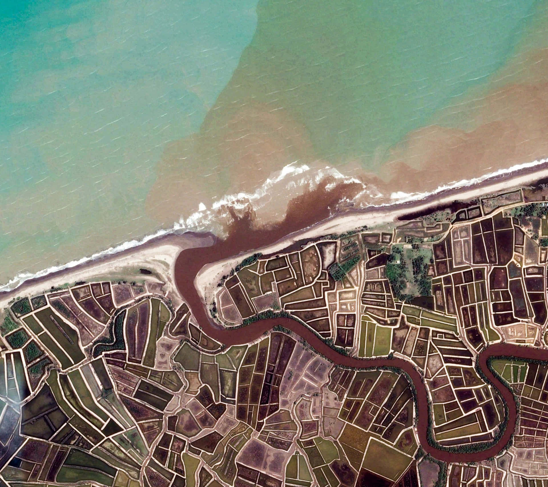 Et luftfoto af en flod og jord med efterårsfarver Wallpaper