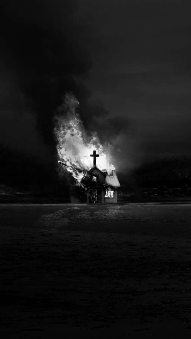 Et sort og hvidt billede af en kirke, der brænder i nattehimlen. Wallpaper
