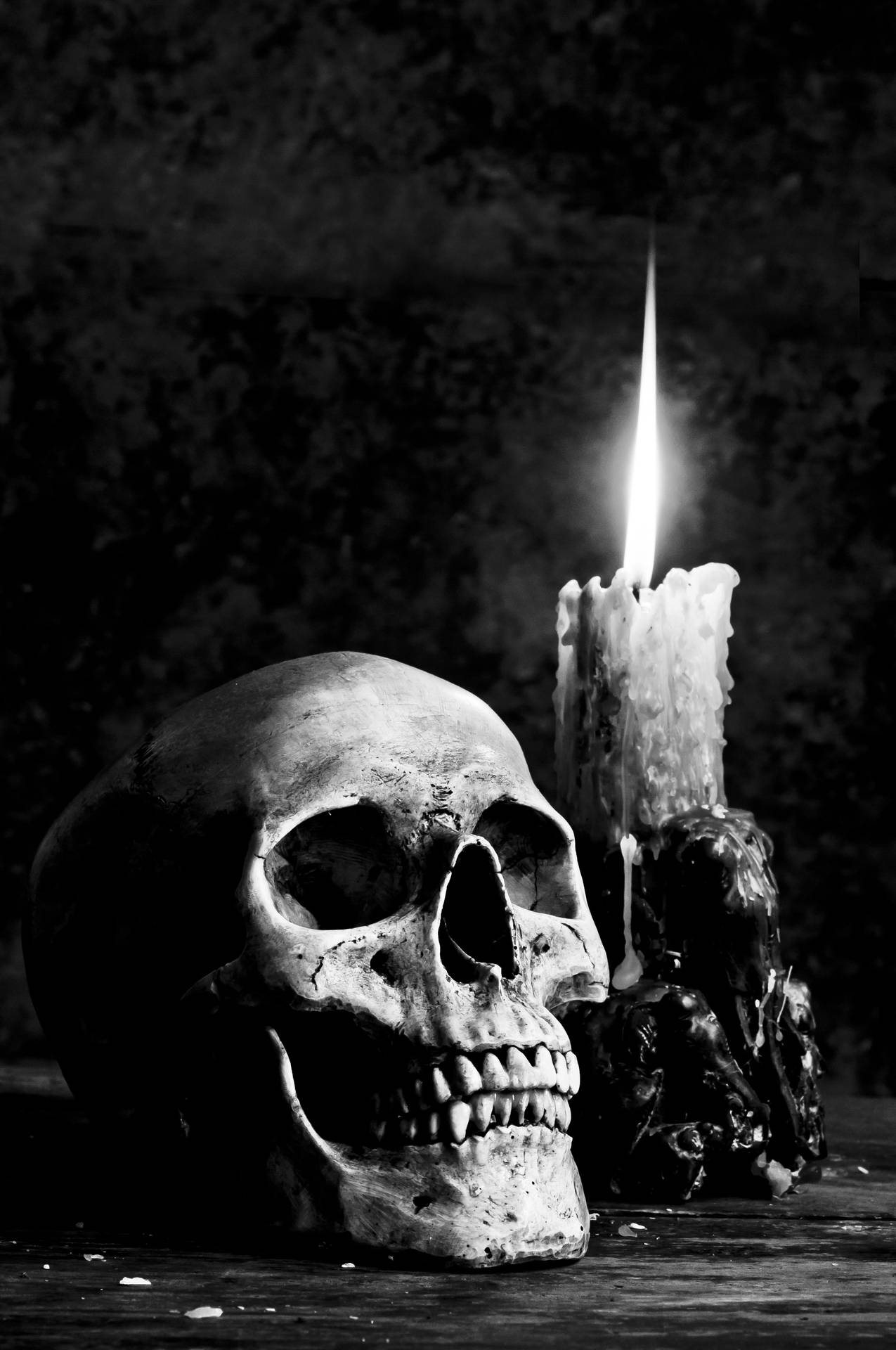 Et skelet og en stearinlyse på et bord. Wallpaper