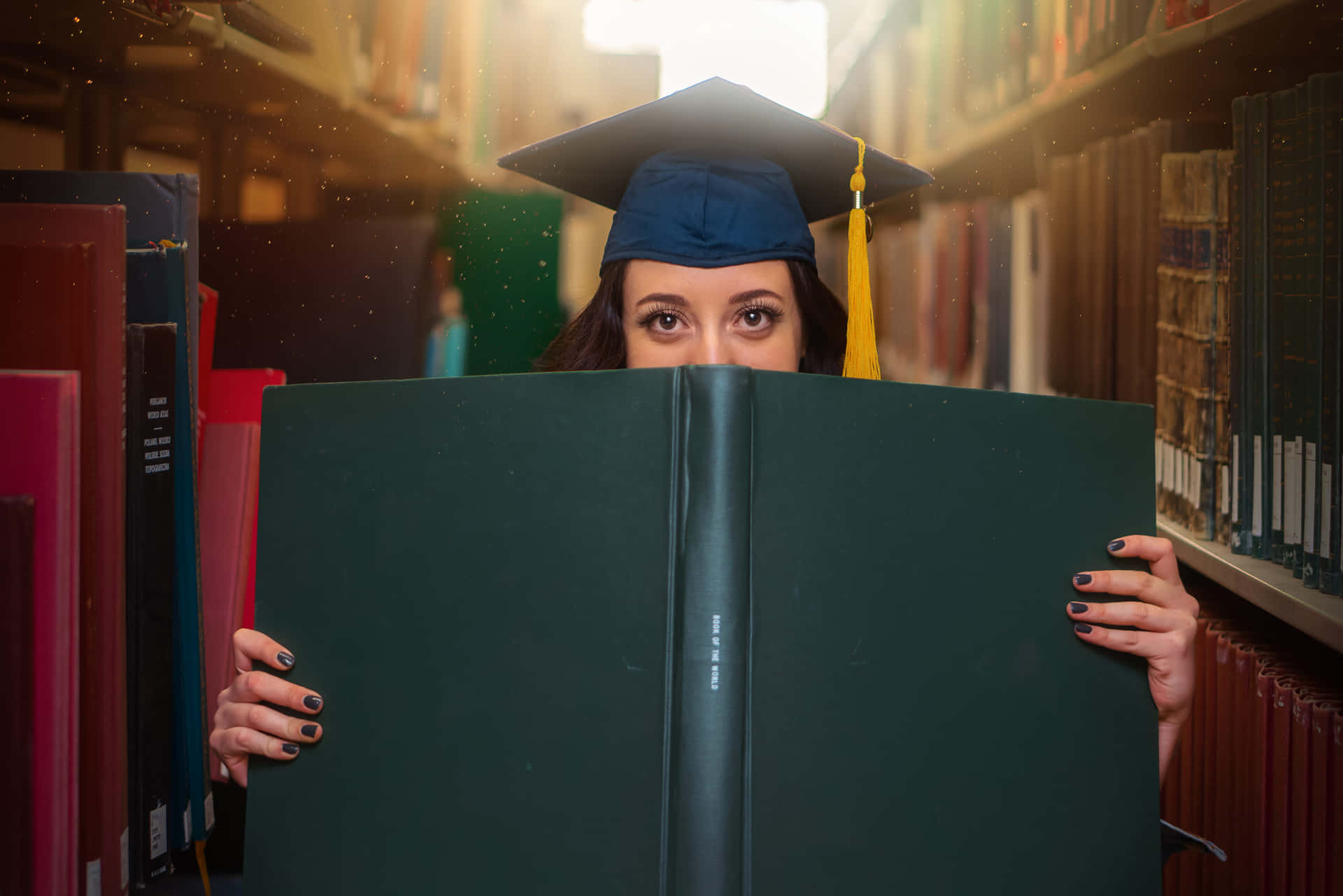 Graduate Student Hiding Behind Book Wallpaper