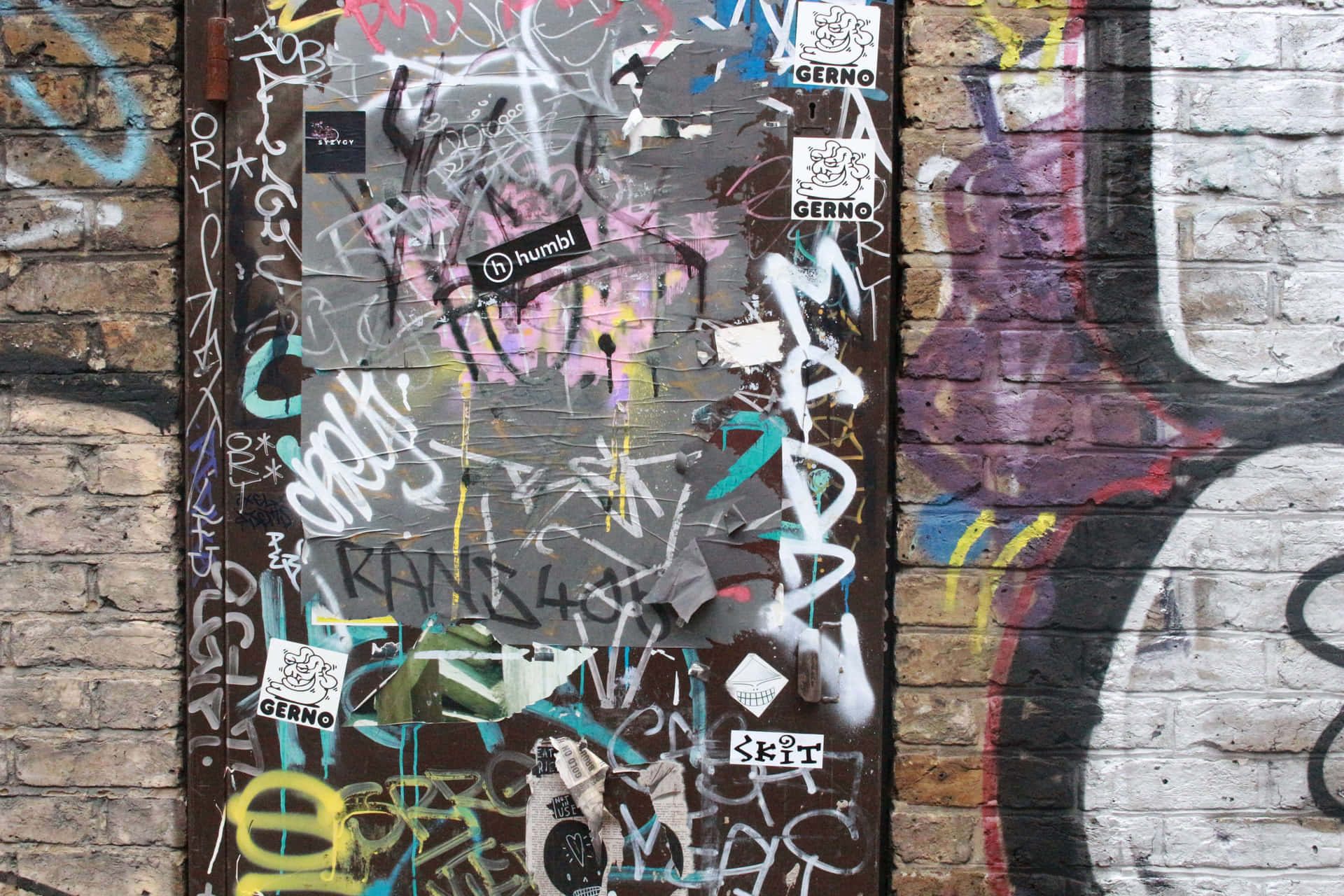 En mur af mursten indhyllet i psykedelisk 4K-graffiti Wallpaper