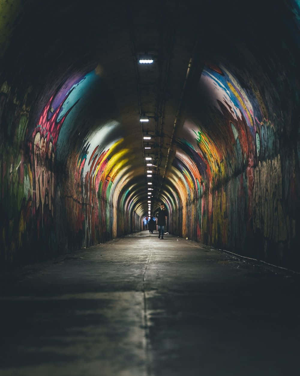 Graffiti Adorned Tunnel With Pedestrians Wallpaper