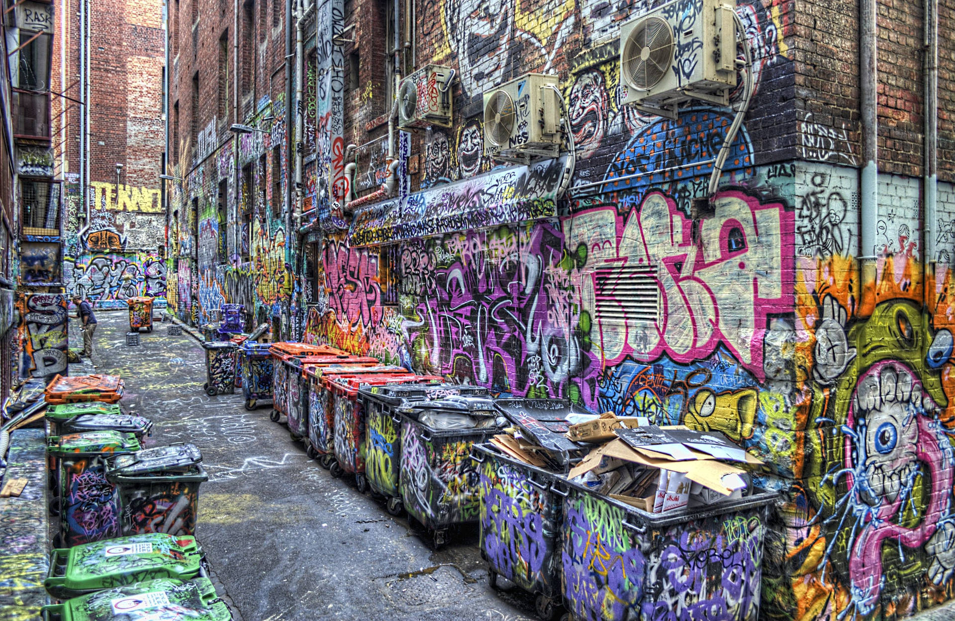 Wallpaper of city block street filled with colorful graffiti. 