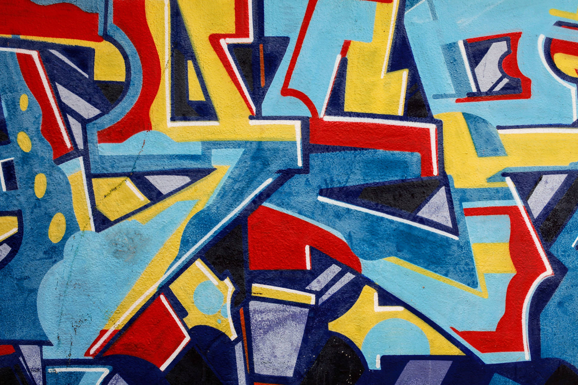 Graffiti wallpaper of blue yellow and red colors abstract with rough texture.