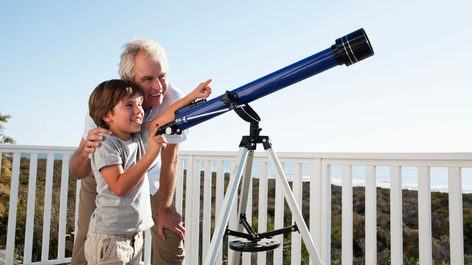 Grandfather And Grandson Using Astronomy Telescope Wallpaper