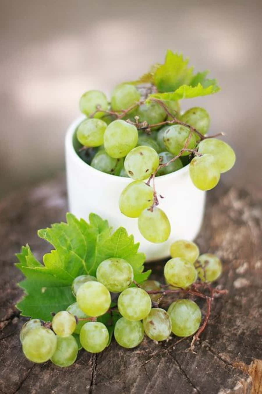 A White Bowl With Green Grapes On Top
