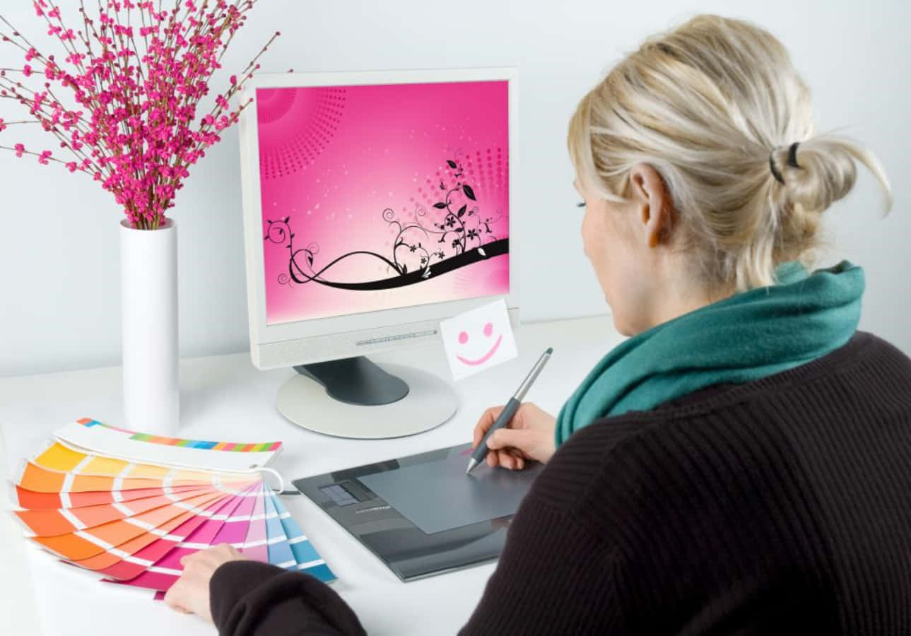 Enkvinde Arbejder På En Computer Med En Lyserød Farvepalette.