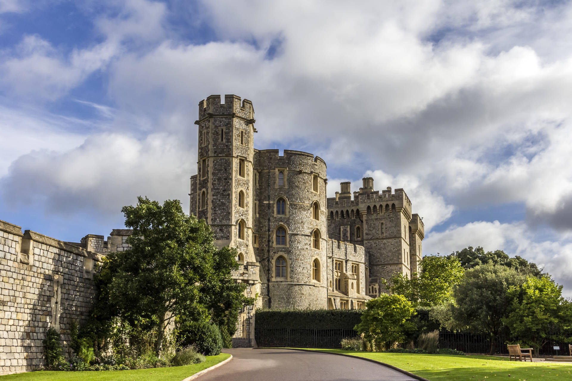 Descrizioneil Maestoso Castello Di Windsor Immerso Nella Rigogliosa Vegetazione Con Uno Spettacolare Cielo Nuvoloso. Sfondo