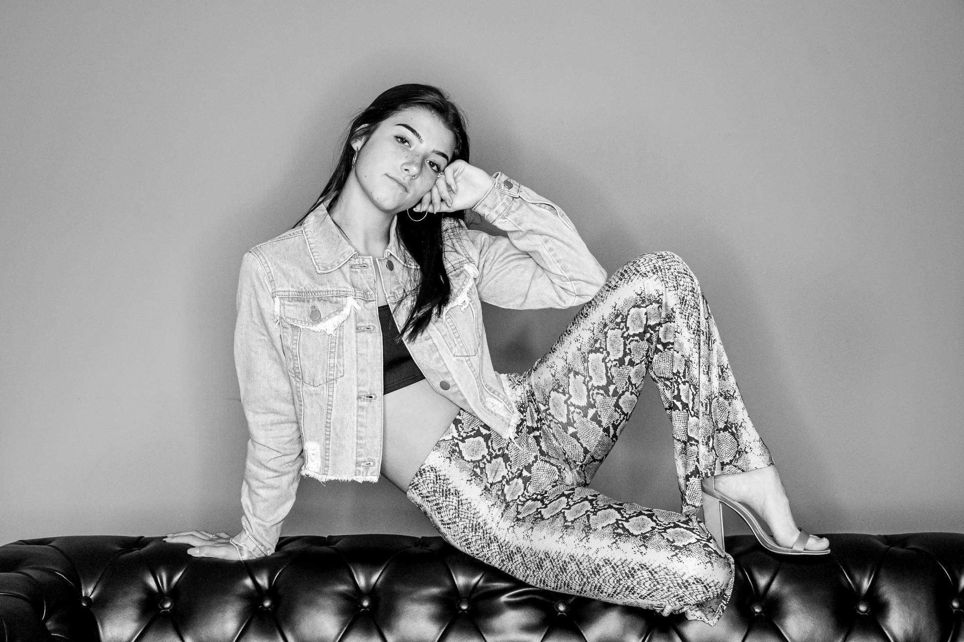 Grayscale Charli Damelio On Couch Wallpaper
