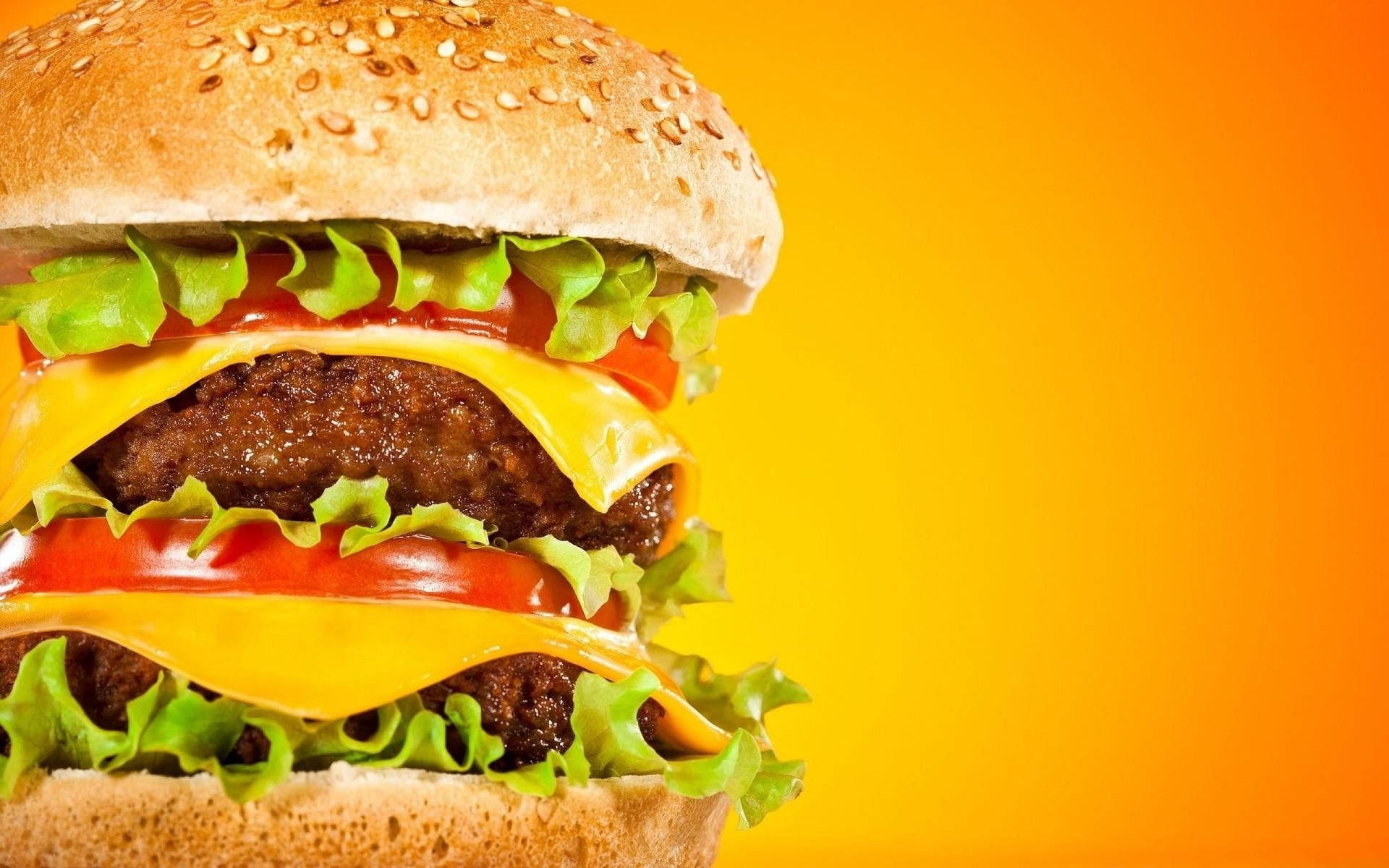 Greasy Cheeseburger On An Orange Background Wallpaper