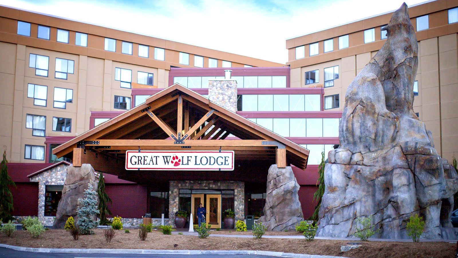 The Entrance To A Hotel With A Large Rock In Front