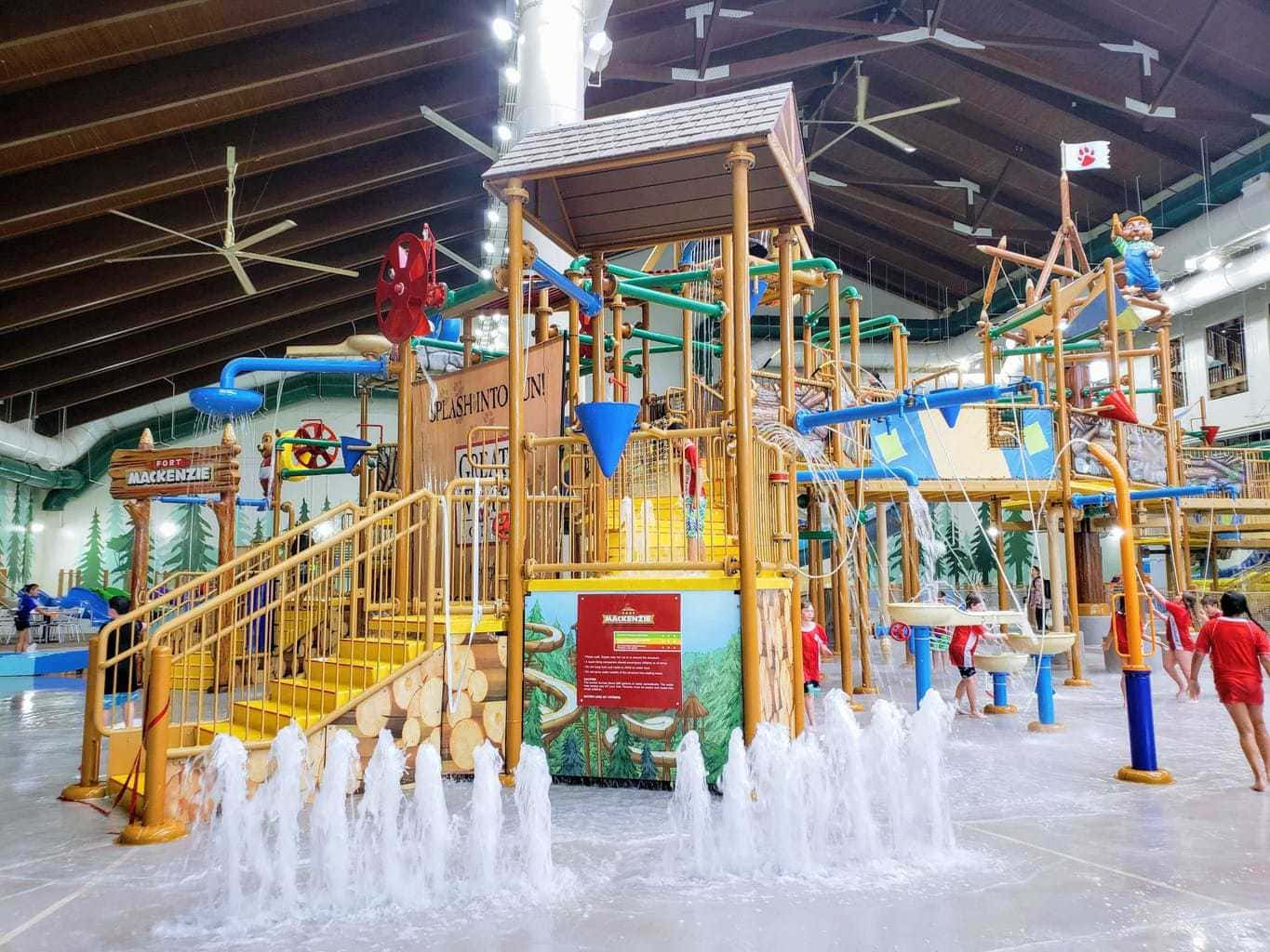 A Water Park With A Slide And Water Fountains