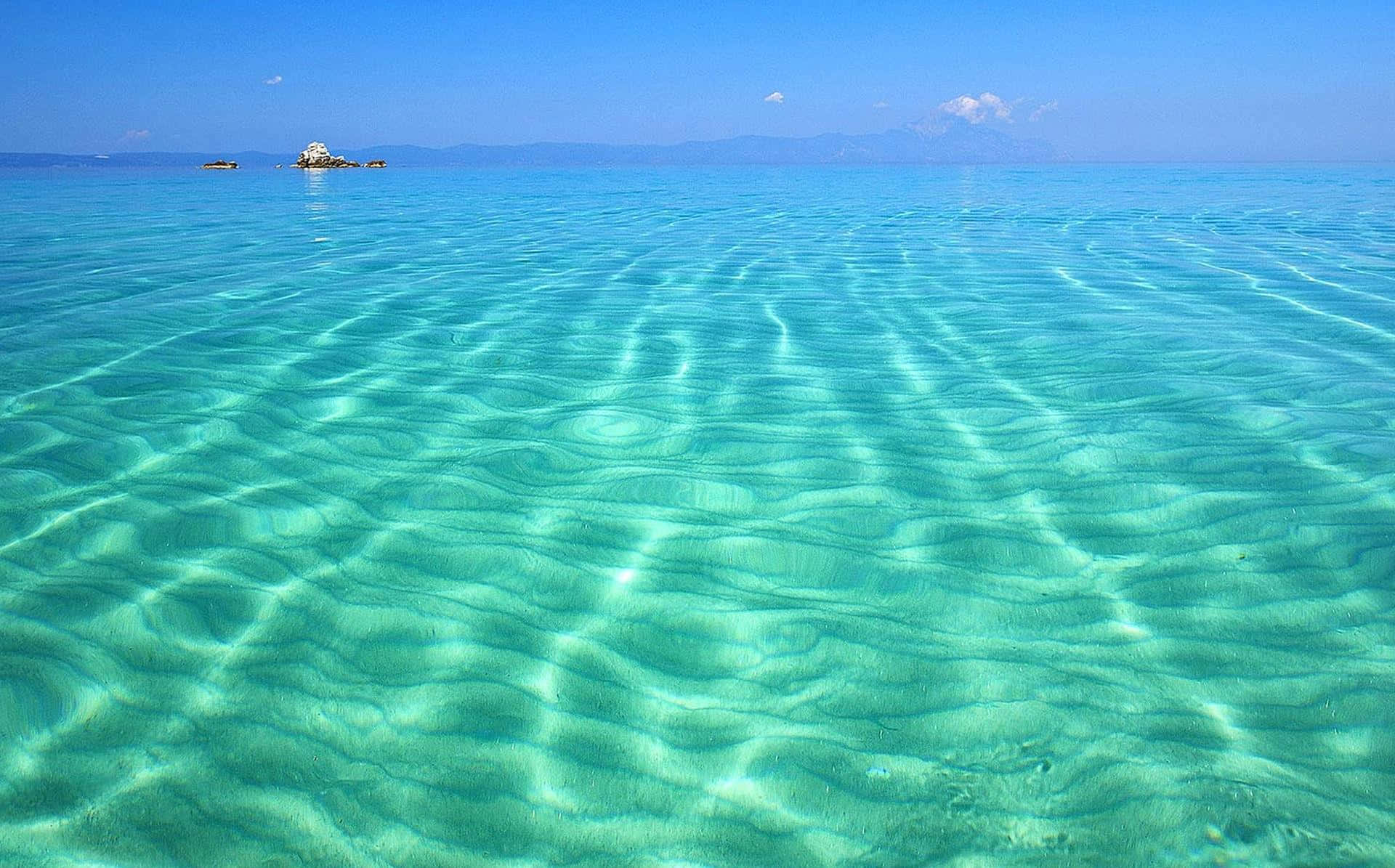 Serene Greek Beach with Turquoise Waters and White Sand Wallpaper