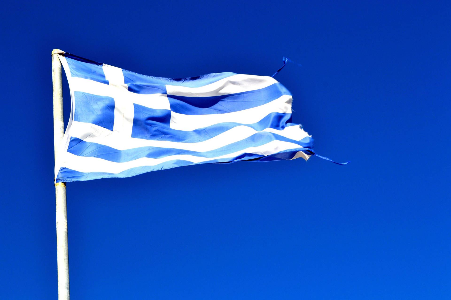 Majestic View of the Greek Flag against a Blue Sky Wallpaper