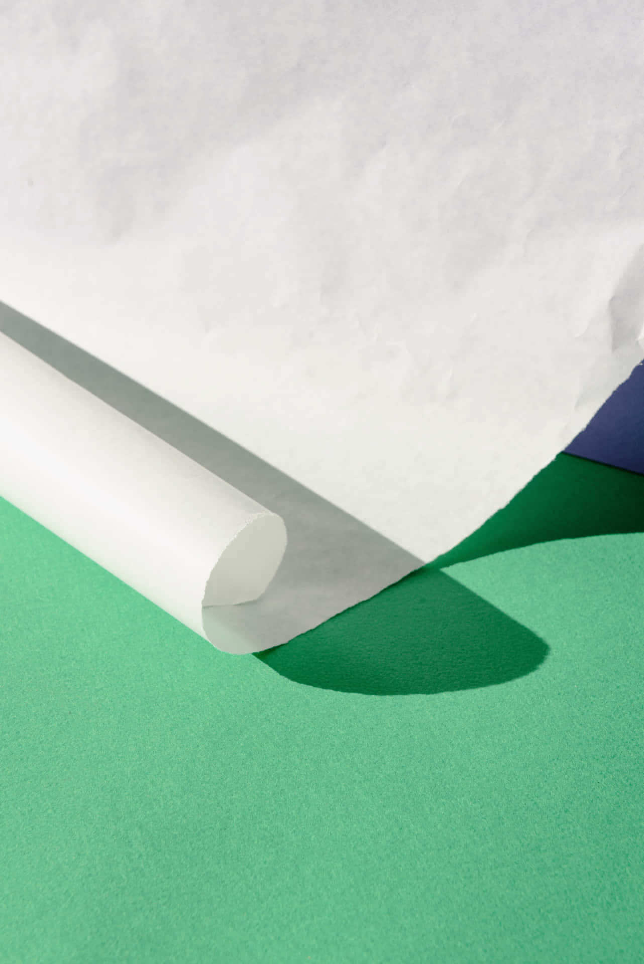 A White Roll Of Paper On A Green Surface