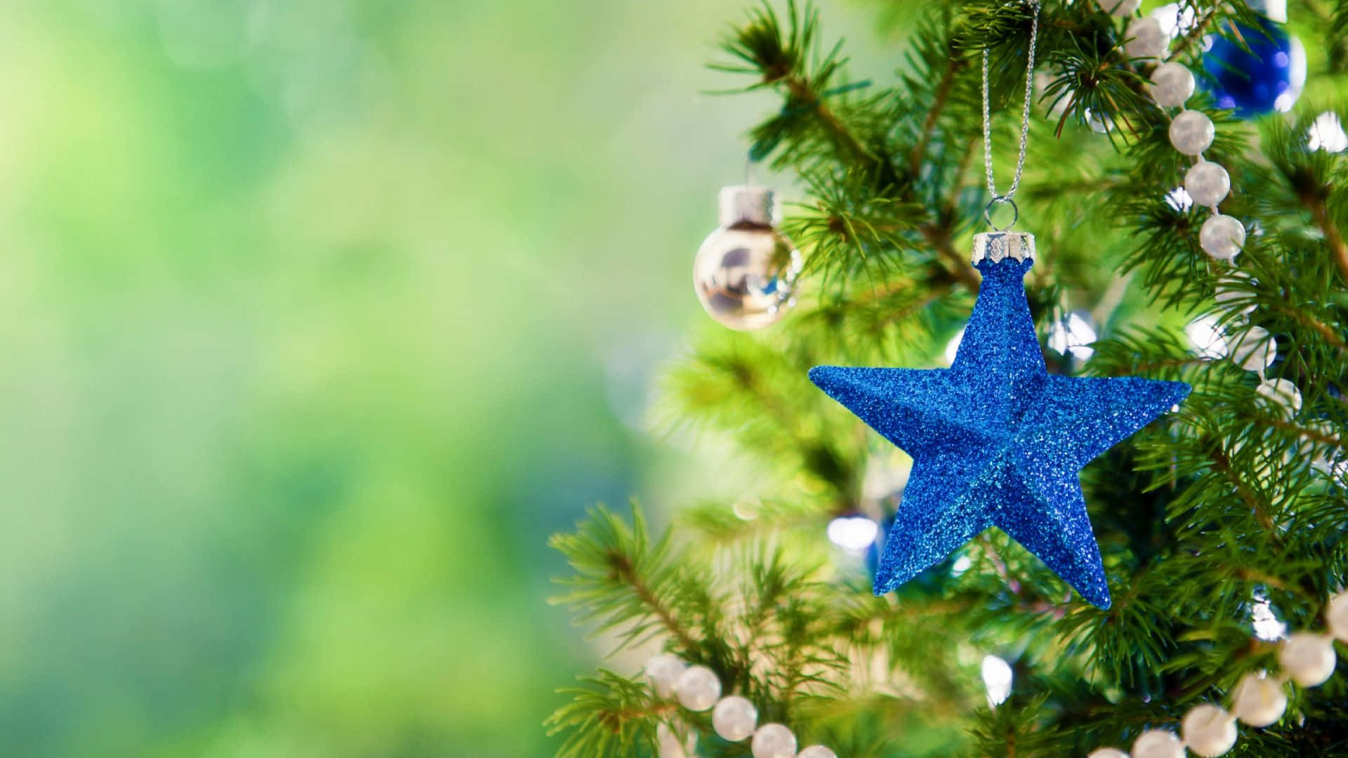 Weihnachtsbaummit Blauen Sternenornamenten Und Perlen Wallpaper