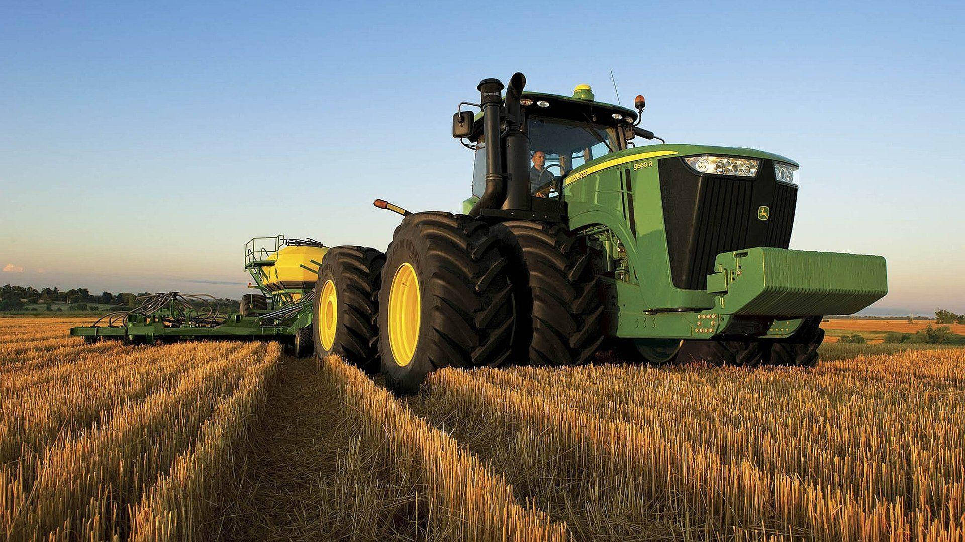 Caption: A pristine John Deere 9R Series Tractor standing tall in a grand landscape. Wallpaper