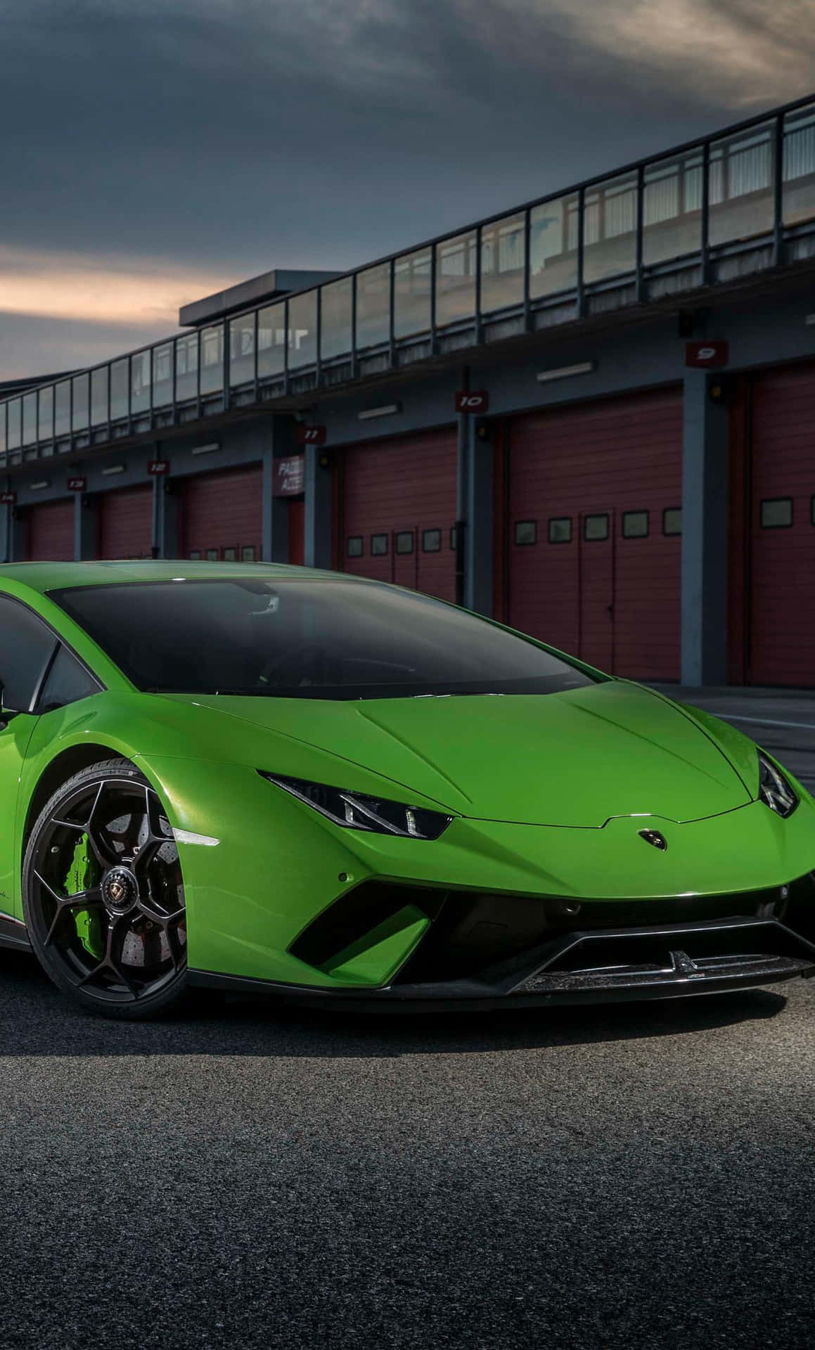 The Green Lamborghini Huracan Is Parked In Front Of A Building Wallpaper