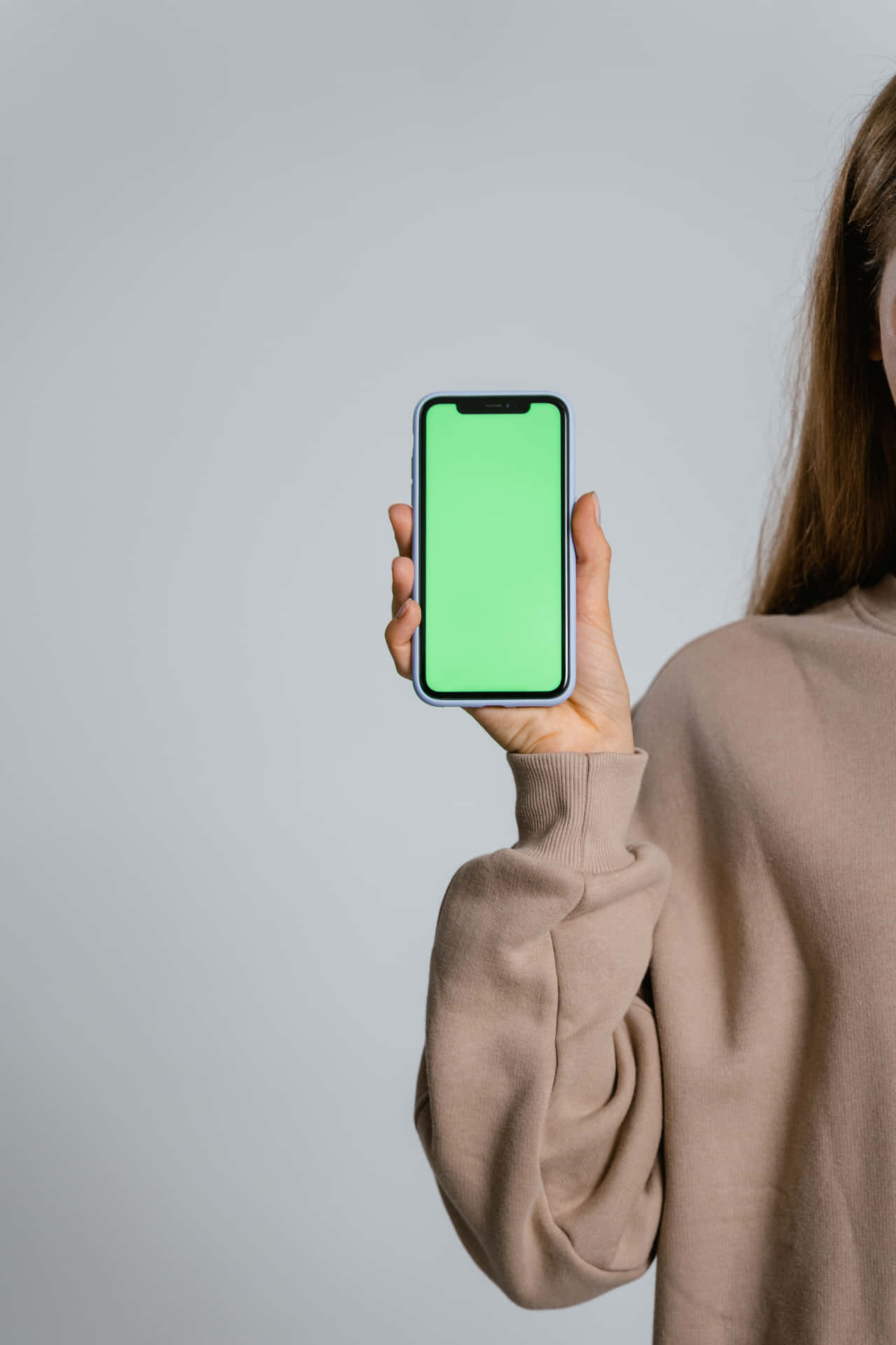 Woman Holding Up Green Screen On Iphone X