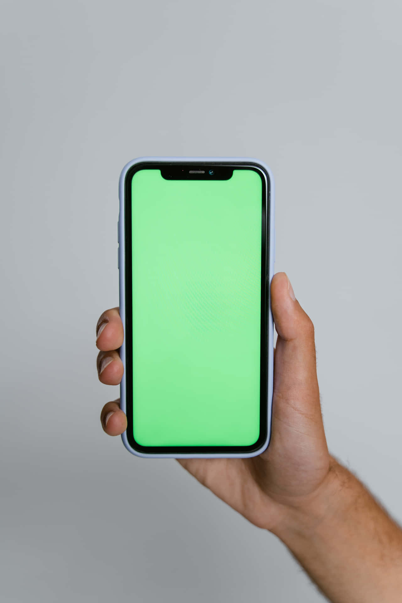 A Man Holding An Iphone X With A Green Screen