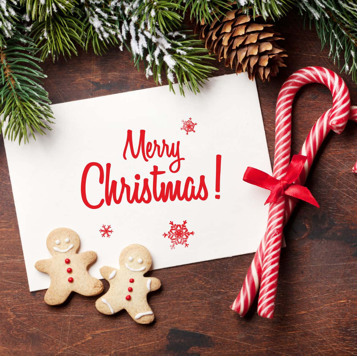 Merry Christmas Card With Gingerbread Cookies And Candy Canes On A Wooden Table