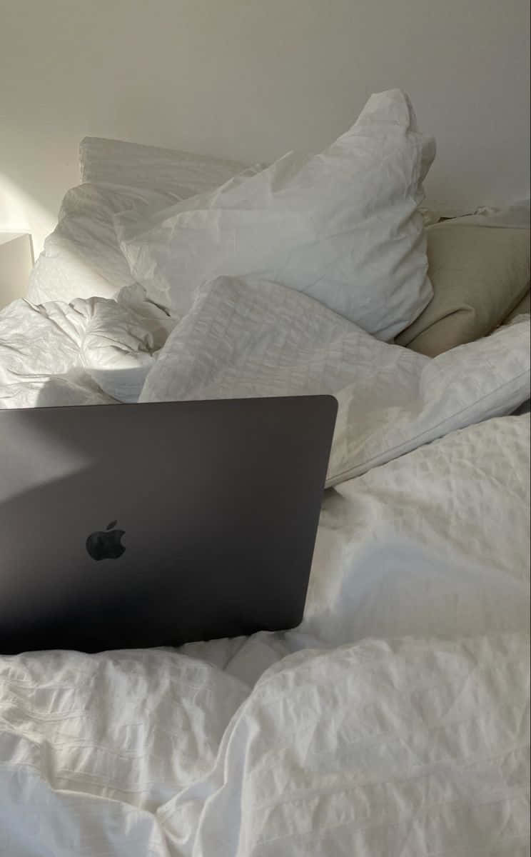 A White Bed With A Laptop On It